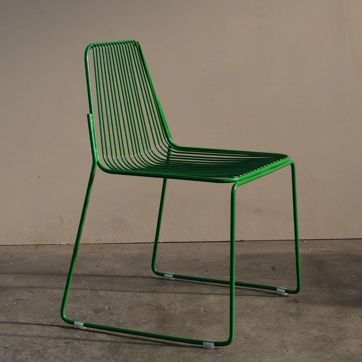 a green chair sitting on top of a cement floor