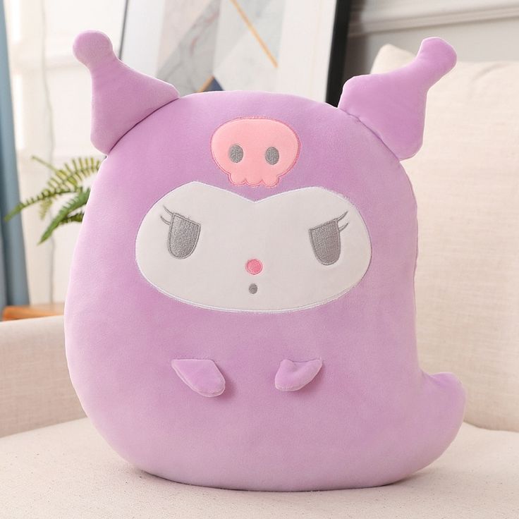 a purple stuffed animal sitting on top of a couch