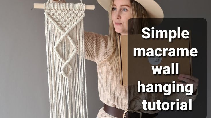 a woman holding up a macrame wall hanging with the words simple macrame wall hanging