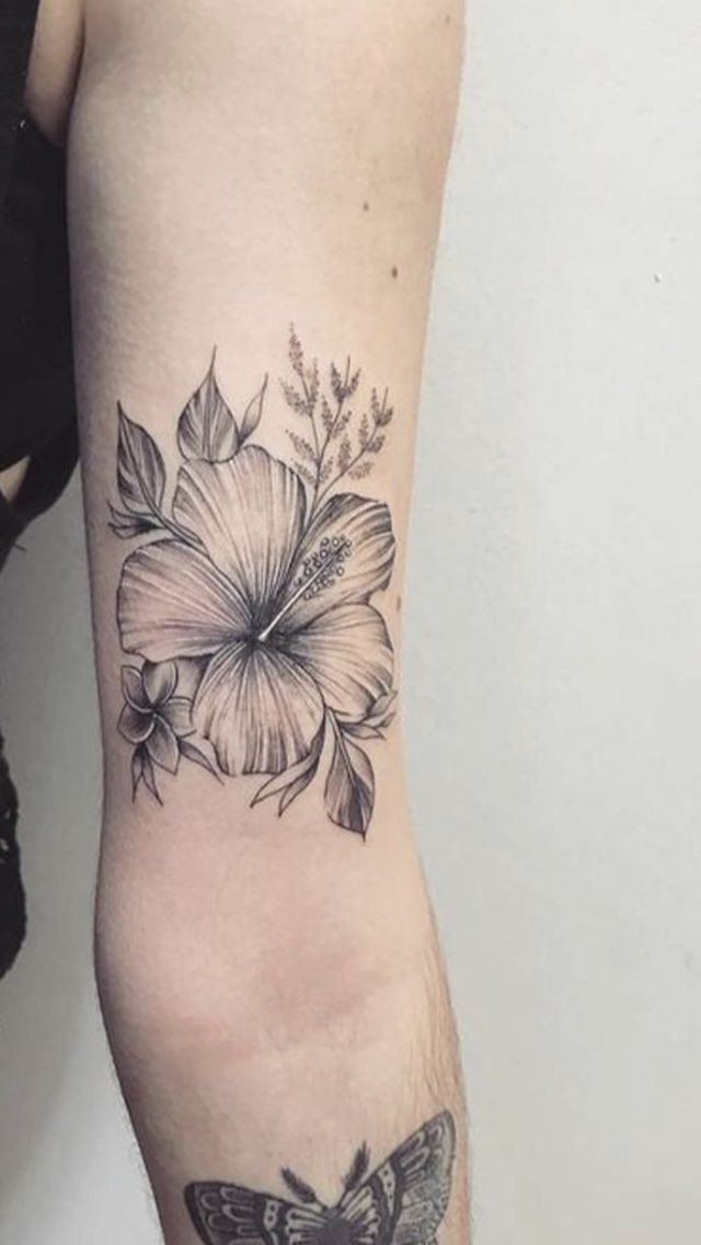 a woman's arm with a butterfly and flower tattoo on the left side of her arm