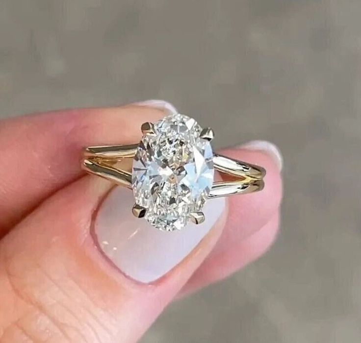 a close up of a person holding a ring with a diamond in it's center