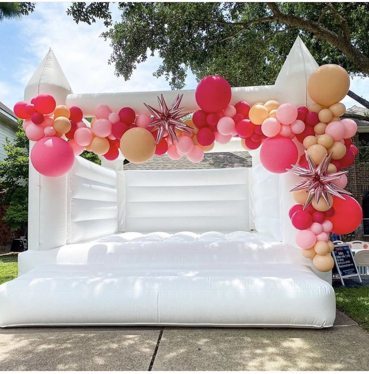 an inflatable bed is decorated with balloons and starbursts for a party