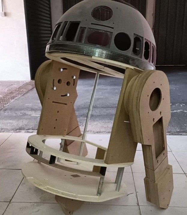 a star wars helmet sitting on top of a wooden stand with holes in it's side