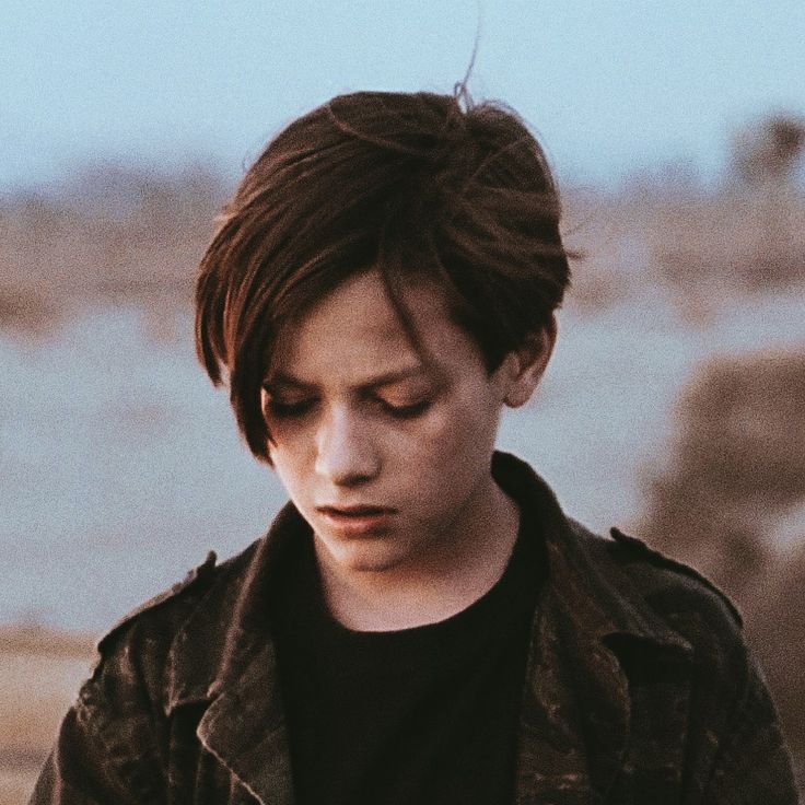 a young man looking down at his cell phone