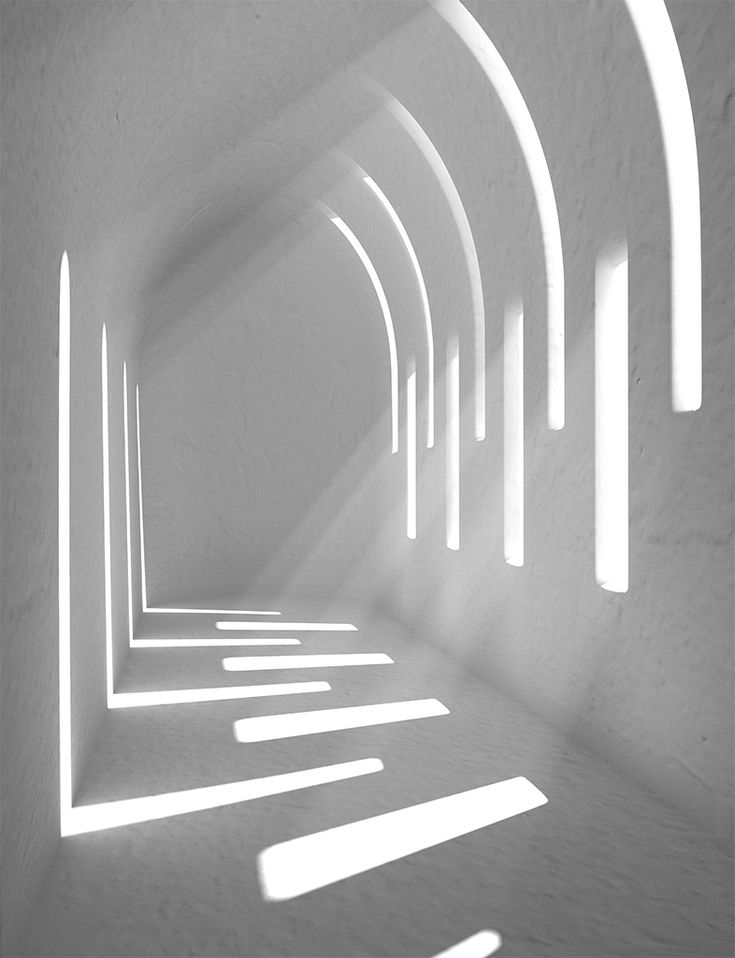 an empty white tunnel with light coming through it