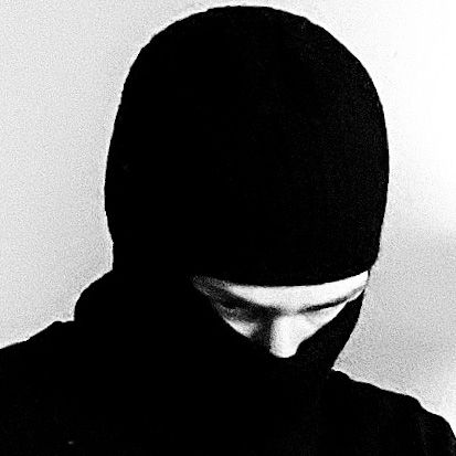 black and white photograph of a person wearing a hood looking down at their cell phone