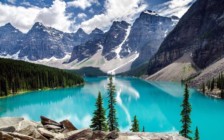 a lake surrounded by mountains and pine trees