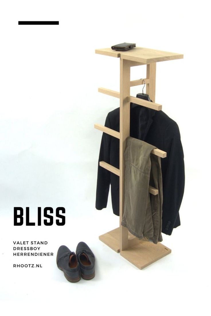 a pair of shoes sitting on top of a wooden shelf next to a coat rack