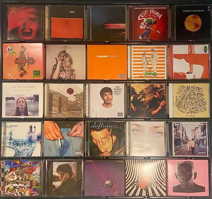 an assortment of cd's are arranged on a wall in front of each other