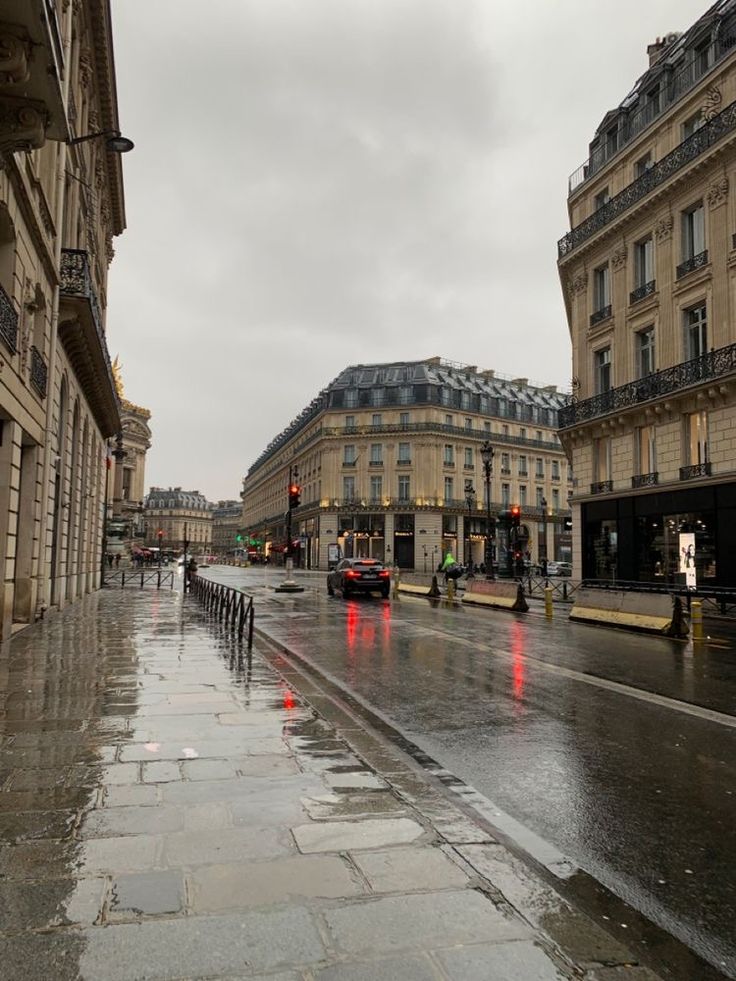 a wet city street with traffic lights and buildings