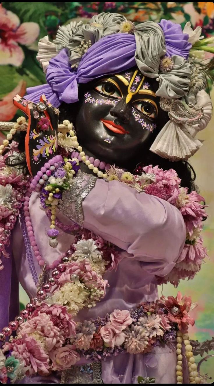 an elaborately dressed woman with flowers on her head and purple hair, wearing a black mask