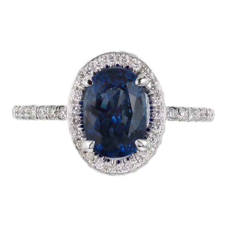 Blue GIA certified 2.02 carat oval sapphire and diamond engagement ring. Oval center stone with a halo of round diamonds. Designed and created in the Peter Suchy Workshop. 1 oval blue sapphire VS2, approx. 2.02cts GIA Certificate # 6204733832 93 round brilliant cut diamonds G-H VS-SI, approx. .60cts Platinum Tested: Platinum 4 grams Width at top: 11.6mm Height at top: 6.5mm Width at bottom: 1.4mm Sapphire Engagement Ring Halo, Sapphire And Diamond Engagement Ring, Edwardian Engagement Ring, Timeless Engagement Ring, Gia Certificate, Contemporary Engagement Rings, Split Shank Engagement Rings, Engagement Ring Oval, Blue Diamond Ring