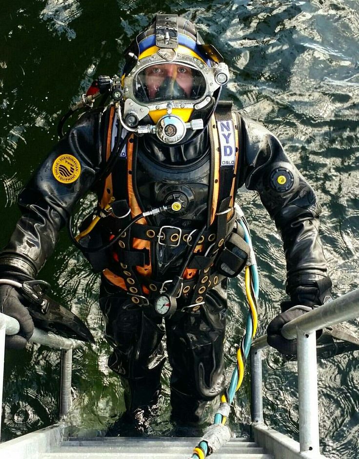 a man in diving gear standing on the edge of a boat