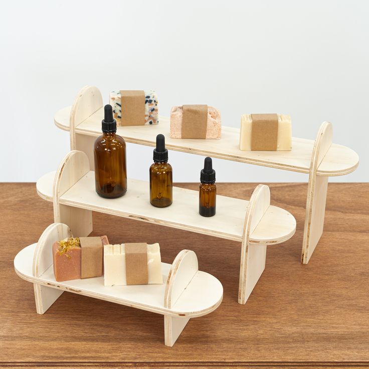 two shelves with soaps and bottles on them sitting on a wooden table next to each other