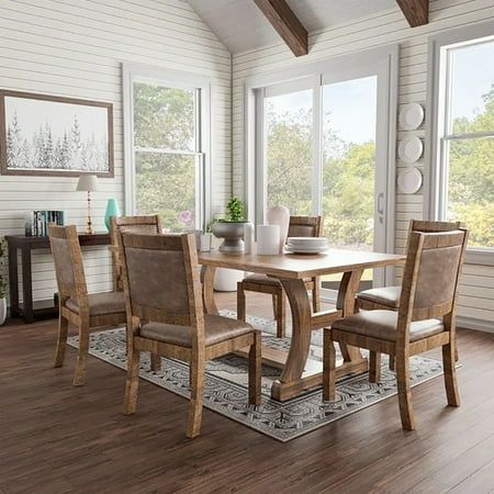 a dining room table and chairs in front of large windows