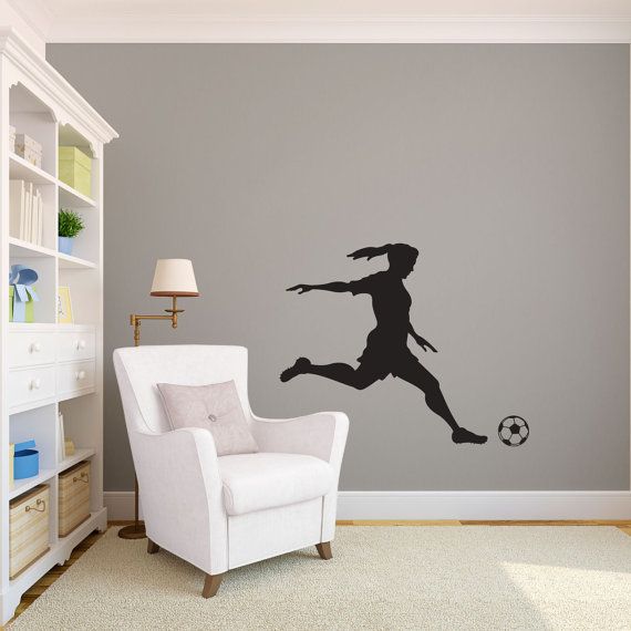 a soccer player kicking the ball wall decal in a room with a white chair