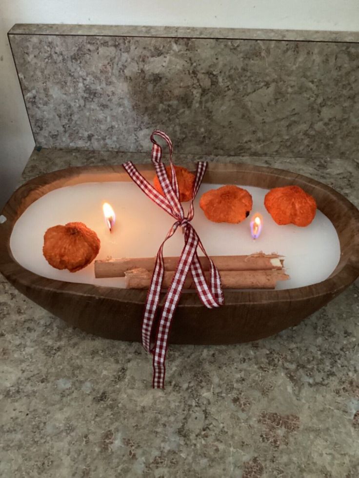 some cinnamons are on a tray with two candles in it and one is tied up