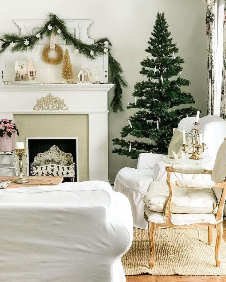 An empty fireplace with olive-gray paint is filled with a vintage log holder painted white. The trellising pattern of the log holder is replicated along the white wood mantel with a gold metal decal. Various gold-themed holiday decor accents are placed across the top of the mantel...   Image: tracey_hiebert