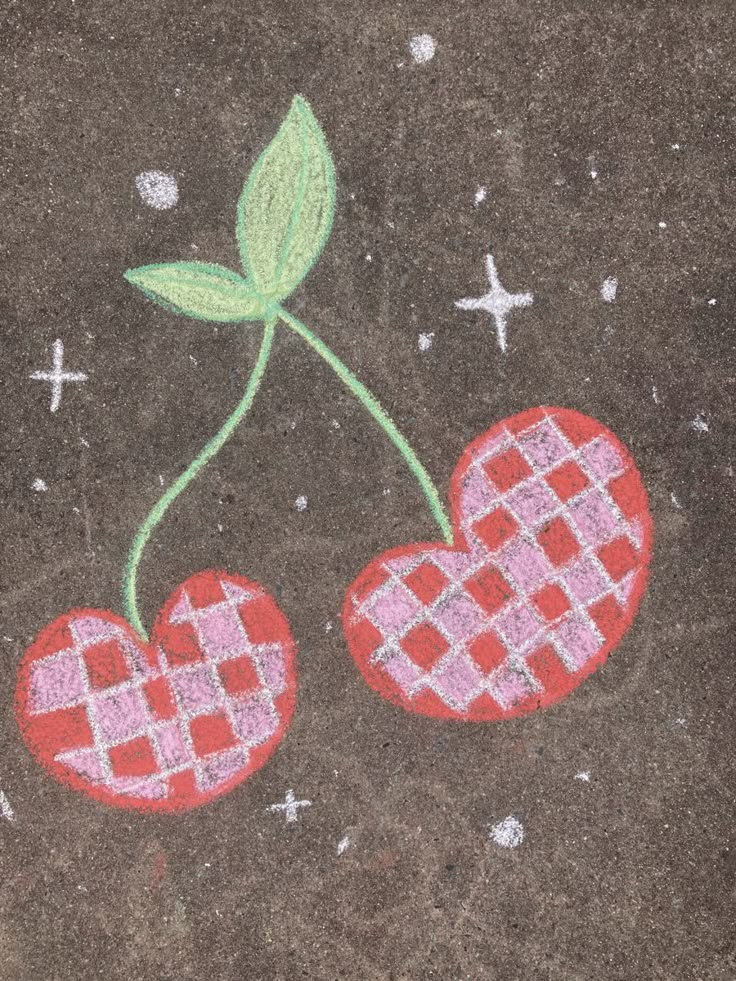 two cherries are drawn on the ground with colored chalk