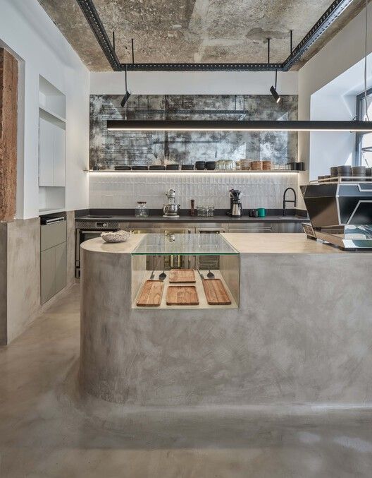 an industrial kitchen with concrete counter tops and stainless steel appliances