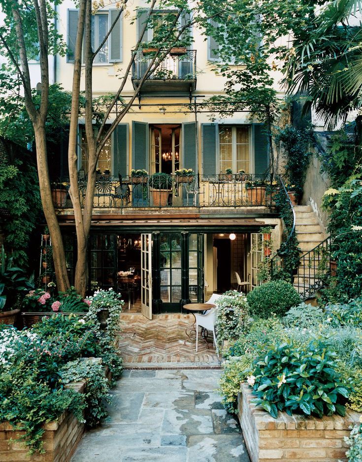 an apartment building with lots of trees and plants