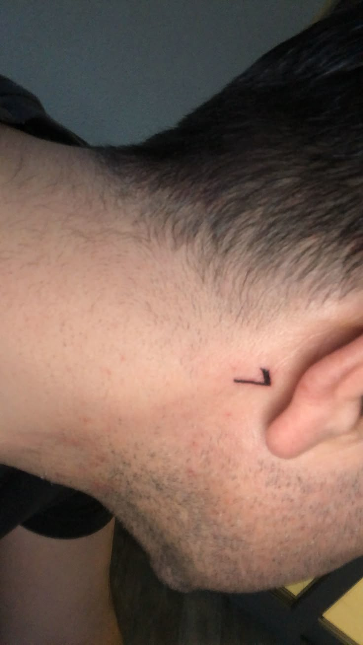 a close up of a person's ear with a small tattoo on the side