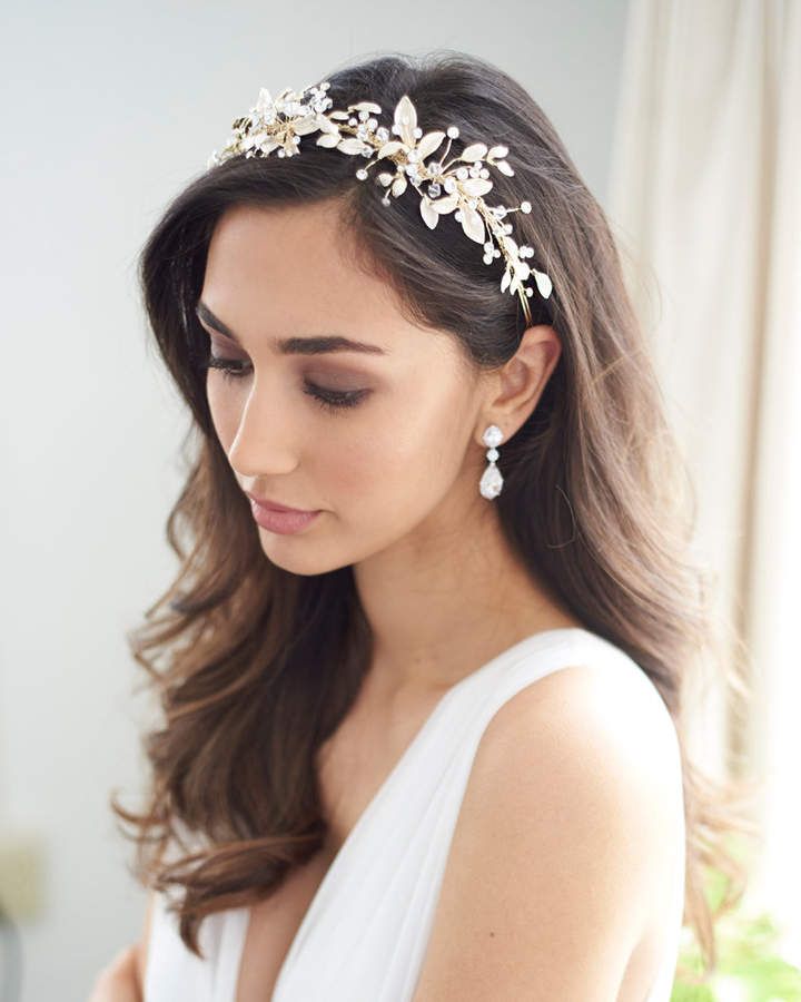 a woman wearing a bridal headpiece with flowers on it