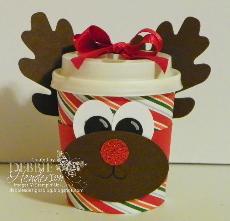 a coffee cup with reindeer's face on it and a red bow around its neck