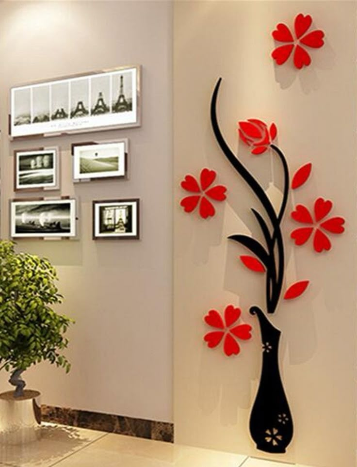 the wall is decorated with red flowers and black vases, which are hanging on it's side