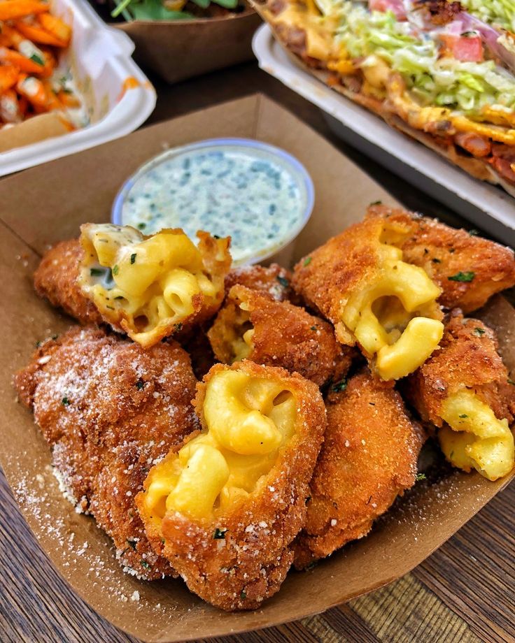 some food is sitting on a table with other foods in bowls and plates behind it