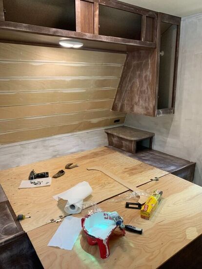 an unfinished kitchen with wood cabinets and tools on the counter top in front of it