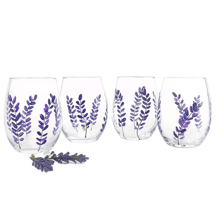 three wine glasses with purple leaves painted on them, one is filled with water and the other has lavender sprigs