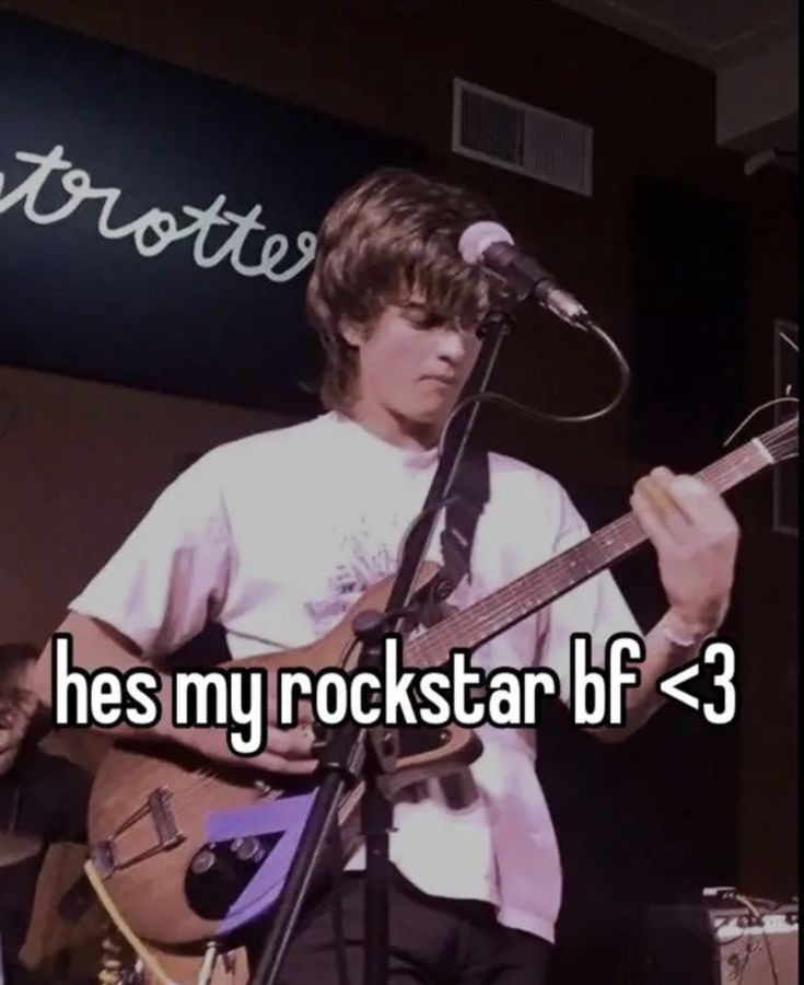 a man holding a guitar in front of a microphone with the words he's my rockstar b f = 3