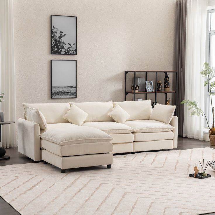 a living room filled with furniture and a white rug on top of a hard wood floor