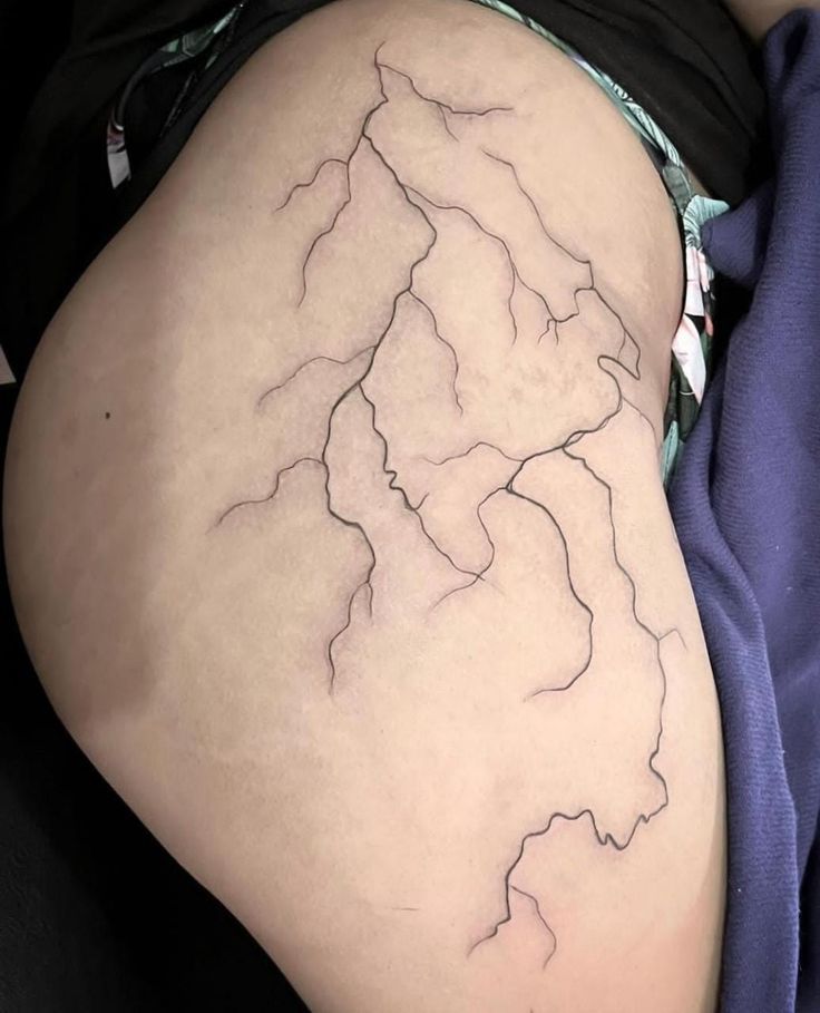 a woman's thigh with a lightning tattoo on it