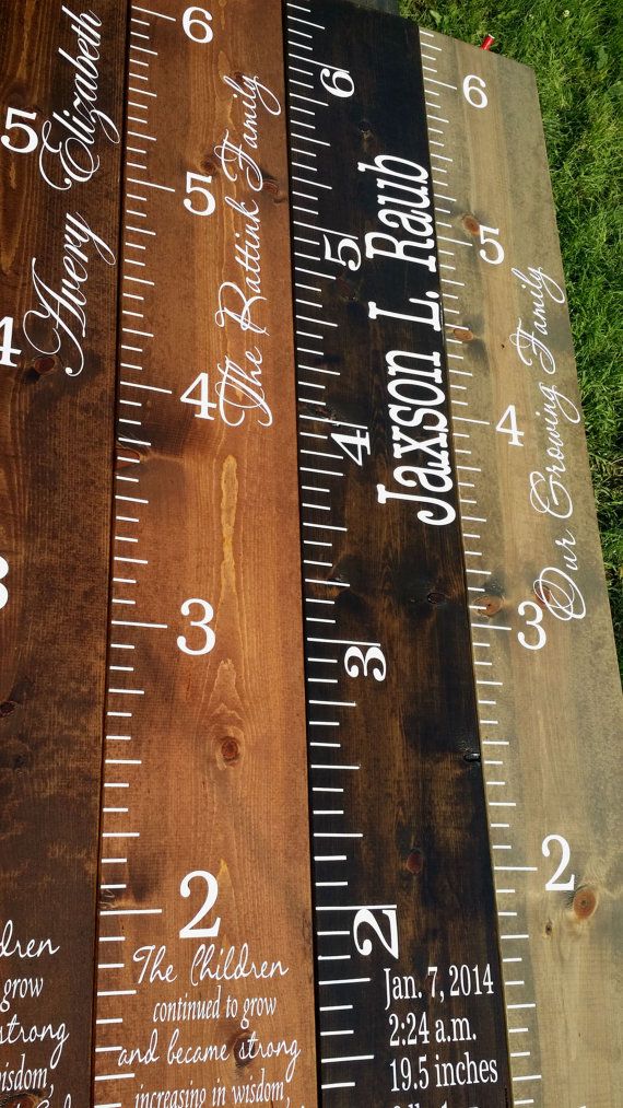 three wooden rulers with numbers on them sitting next to each other in front of some grass