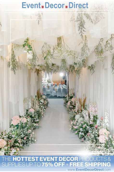 two tables with white linen covered chairs and flowers on the wall in front of them