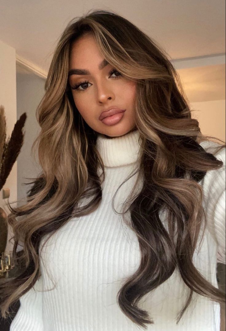 a woman with long hair wearing a white turtle neck sweater