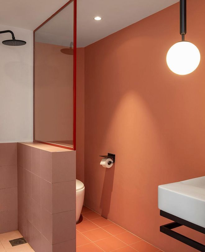 a bathroom with a toilet, sink and shower stall in the middle of the room