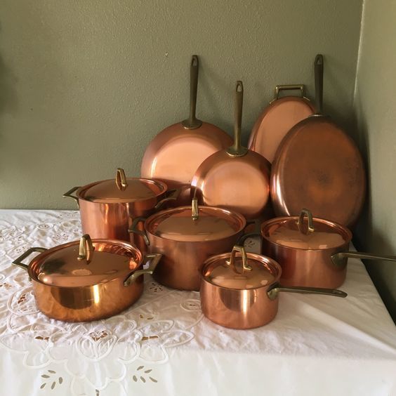 copper pots and pans on a white table cloth