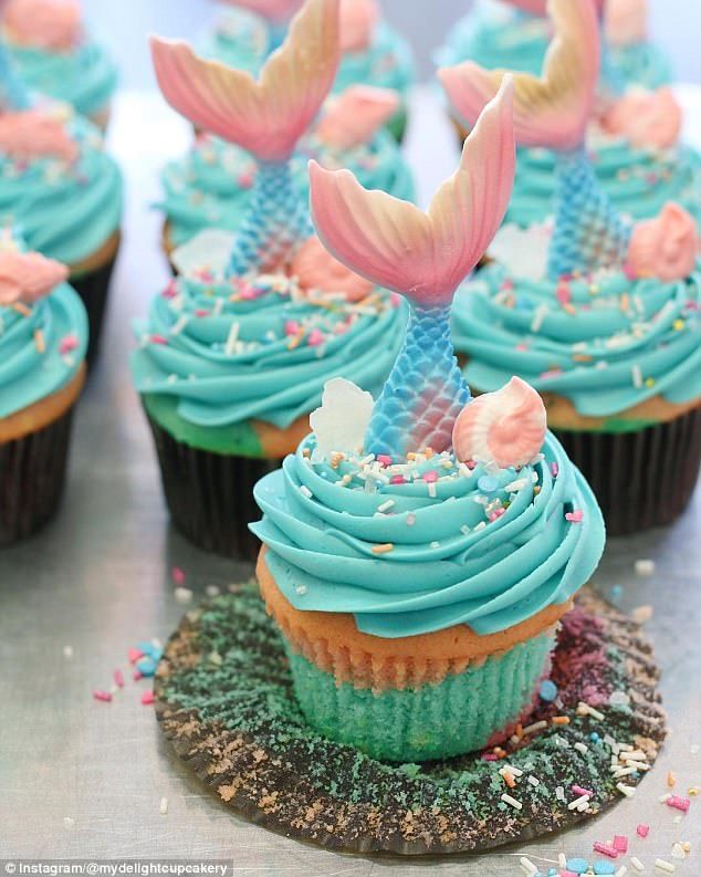 cupcakes decorated with blue frosting and mermaid tail decorations