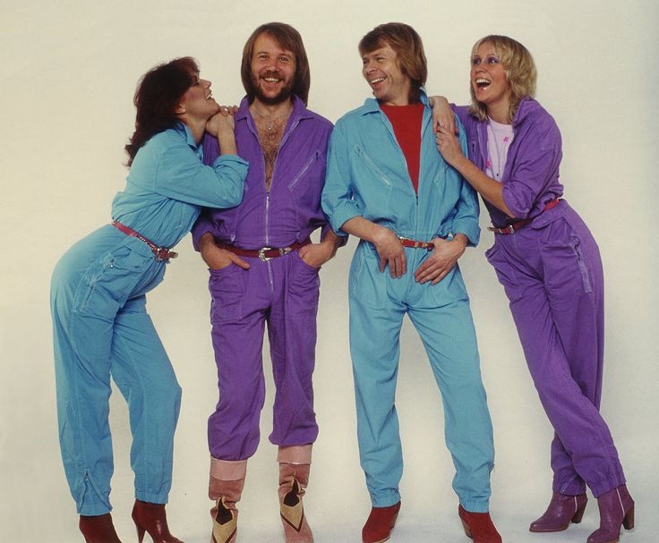 three men in blue and purple jumpsuits standing next to each other with their arms around one another