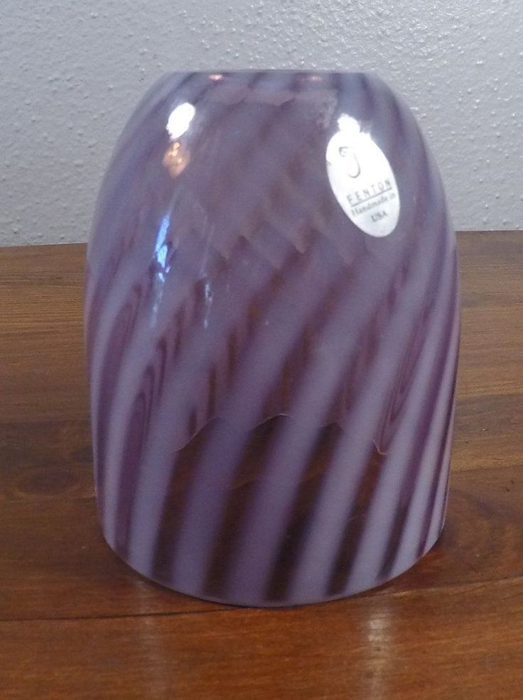 a purple vase sitting on top of a wooden table