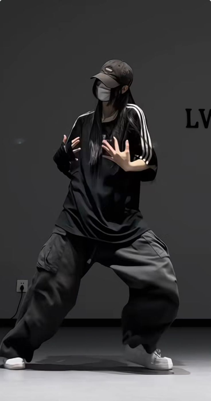 a man in black shirt and pants doing a dance move