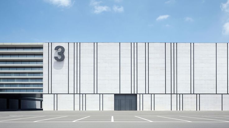 an empty parking lot in front of a large building with a number 3 on it