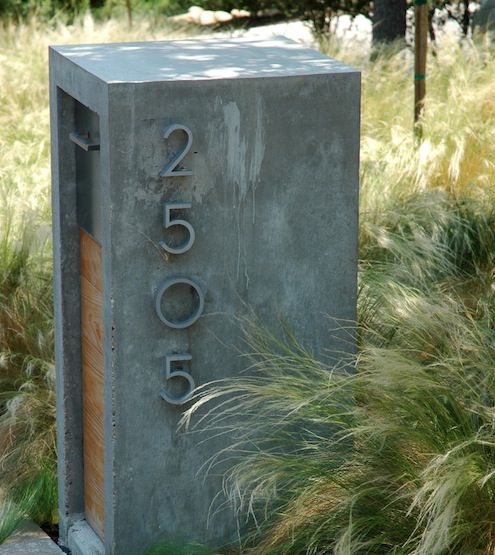 a concrete box sitting in the middle of some grass