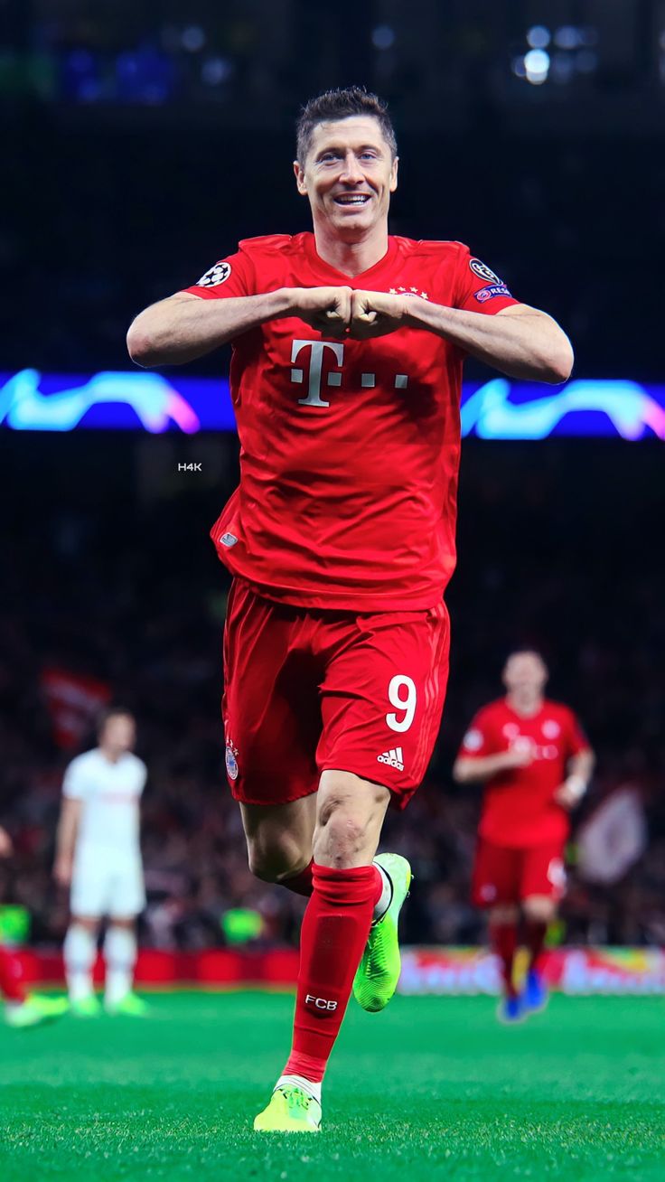 a soccer player is running on the field with his arms crossed and eyes wide open