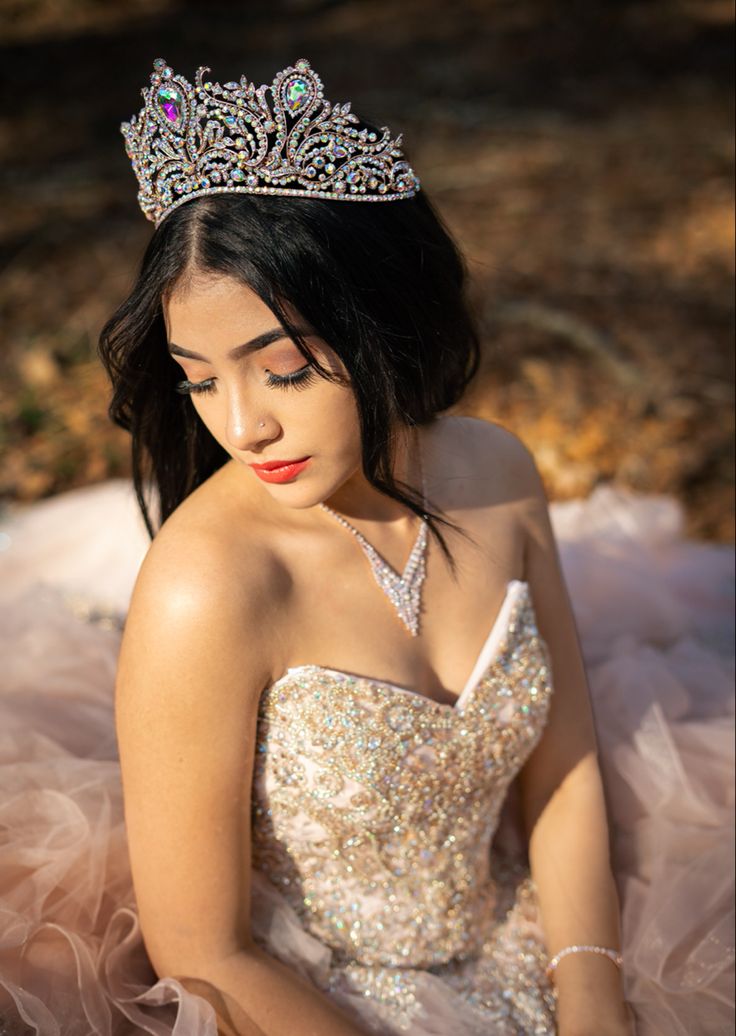 a woman wearing a tiara sitting on the ground