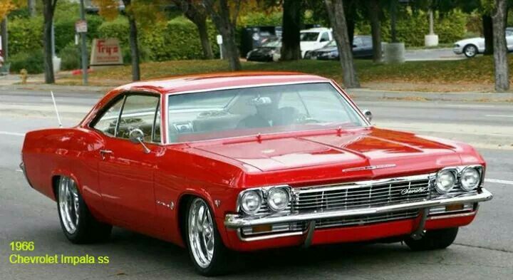 an old red car is parked on the street