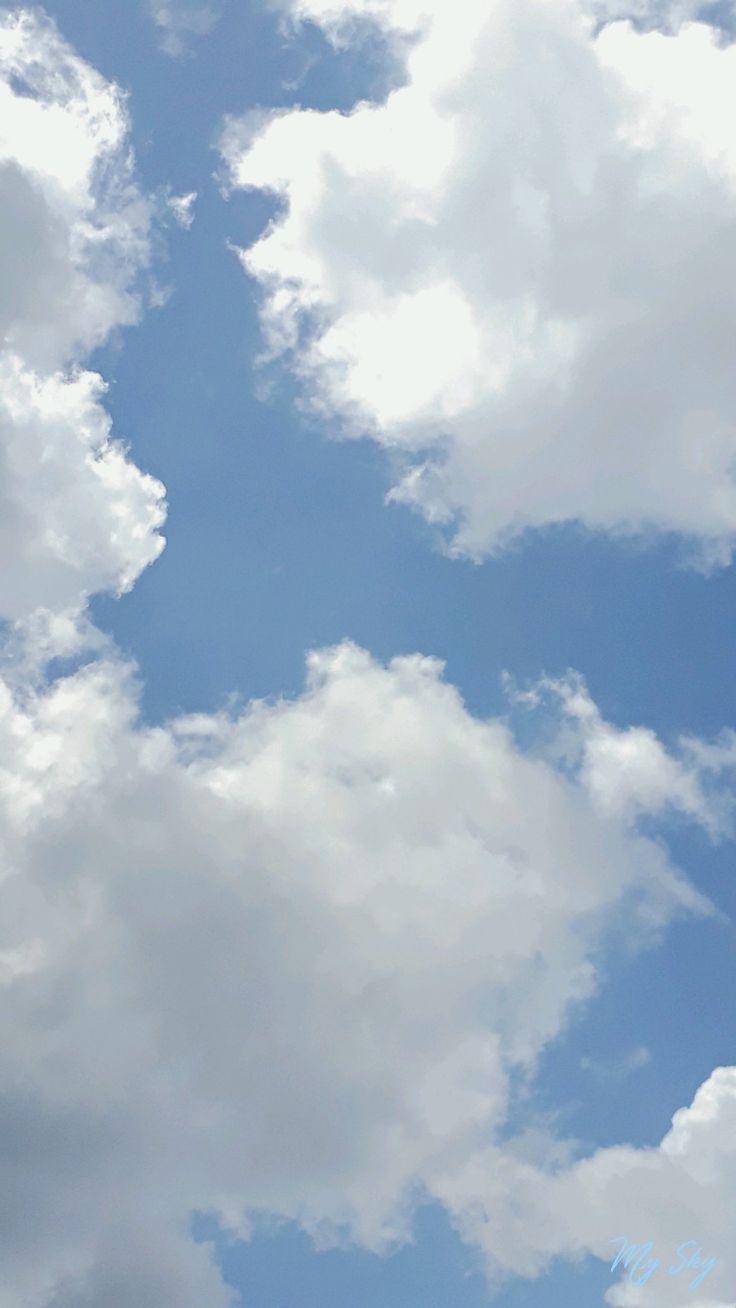 the plane is flying high in the sky with clouds behind it and blue skies above